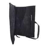 Hand stitched matte black reverse horse culatta leather journal cover with a hand forged solid .925 sterling silver buckle closure and multiple pages of 150gsm handmade cotton rag paper. available to buy online from artisanal uk based leather studio atelier skn.