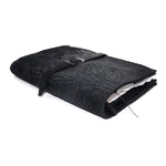 Hand stitched matte black reverse horse culatta leather journal cover with a hand forged solid .925 sterling silver buckle closure and multiple pages of 150gsm handmade cotton rag paper. available to buy online from artisanal uk based leather studio atelier skn.