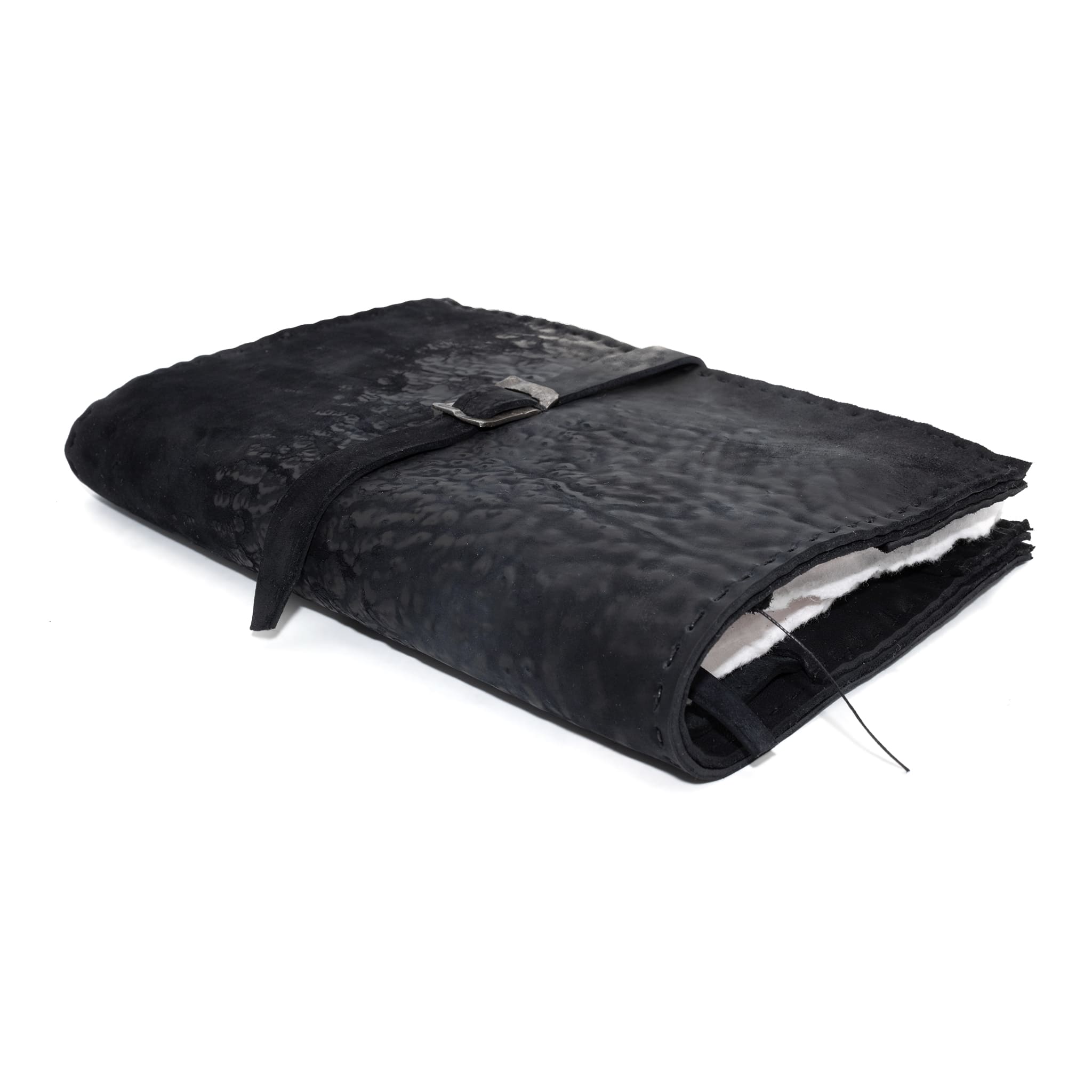 Hand stitched matte black reverse horse culatta leather journal cover with a hand forged solid .925 sterling silver buckle closure and multiple pages of 150gsm handmade cotton rag paper. available to buy online from artisanal uk based leather studio atelier skn.