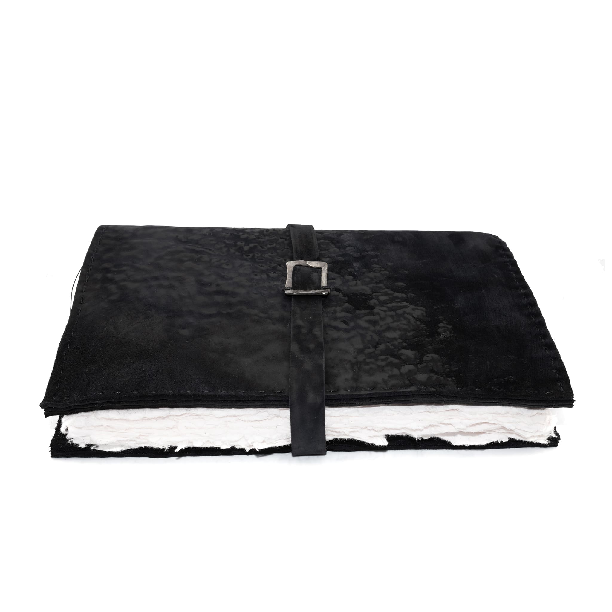 Hand stitched matte black reverse horse culatta leather journal cover with a hand forged solid .925 sterling silver buckle closure and multiple pages of 150gsm handmade cotton rag paper. available to buy online from artisanal uk based leather studio atelier skn.