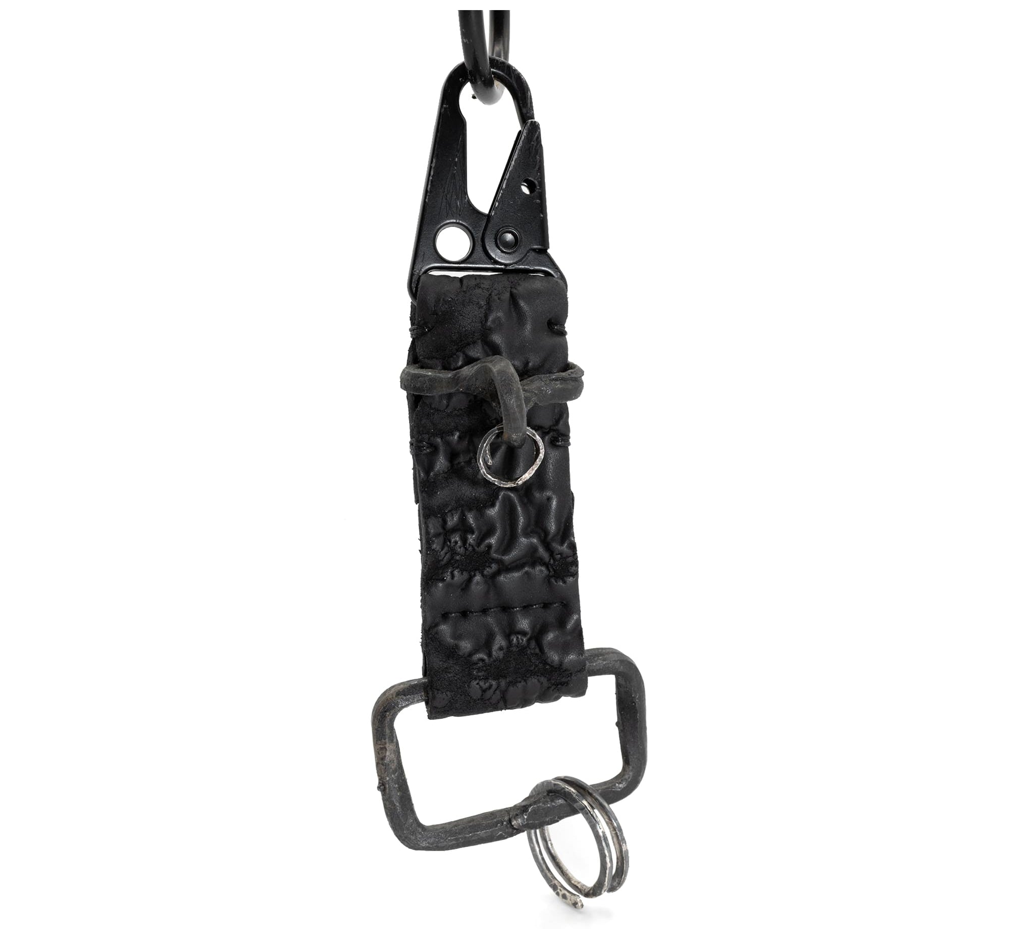 hand stitched and hand dyed reverse horse culatta leather keychain adorned with hand forged iron and .925 sterling silver hardware. a distressed military clip and overlock stitching finish off the keychain. available online from artisanal leather studio atelier skn.