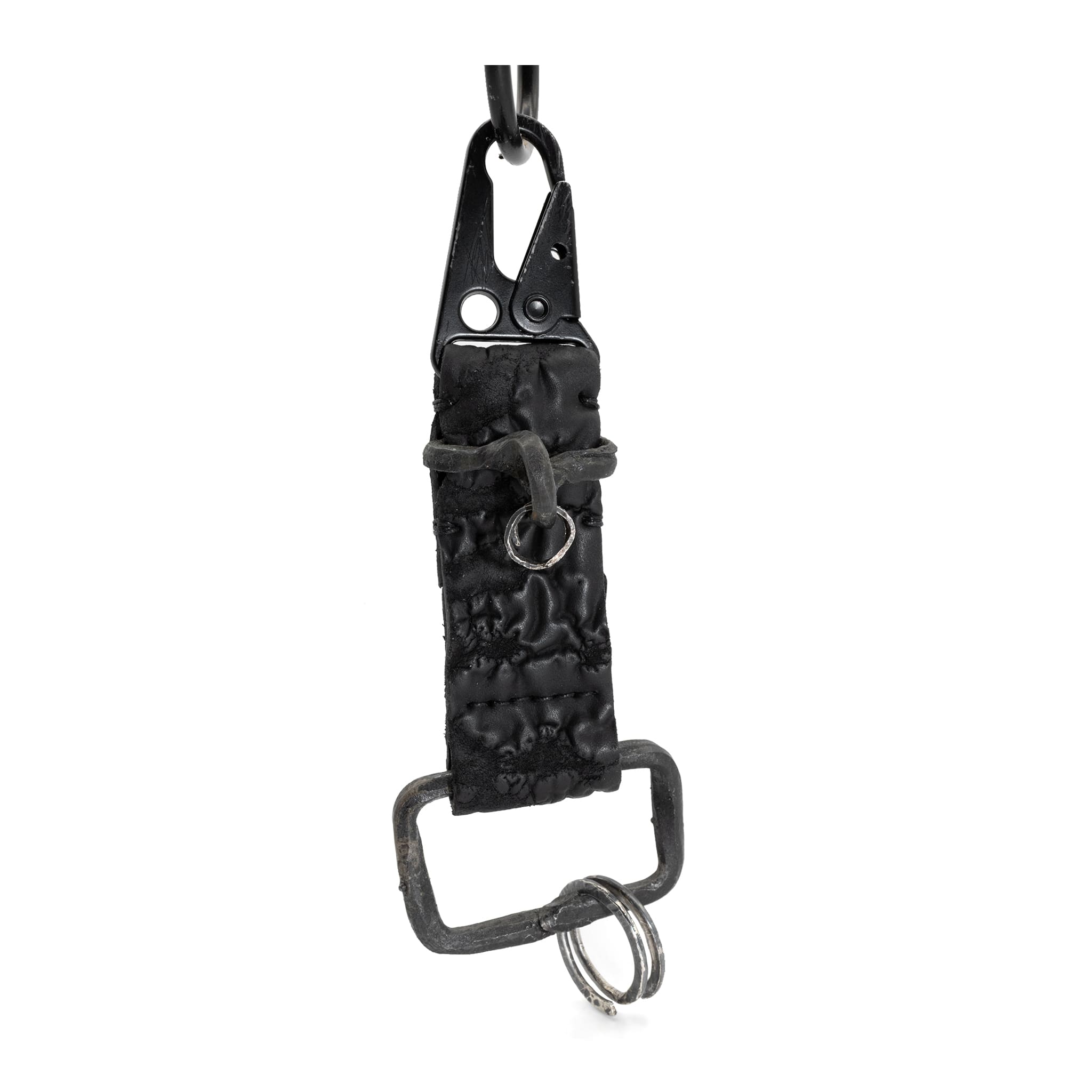 hand stitched and hand dyed reverse horse culatta leather keychain adorned with hand forged iron and .925 sterling silver hardware. a distressed military clip and overlock stitching finish off the keychain. available online from artisanal leather studio atelier skn.