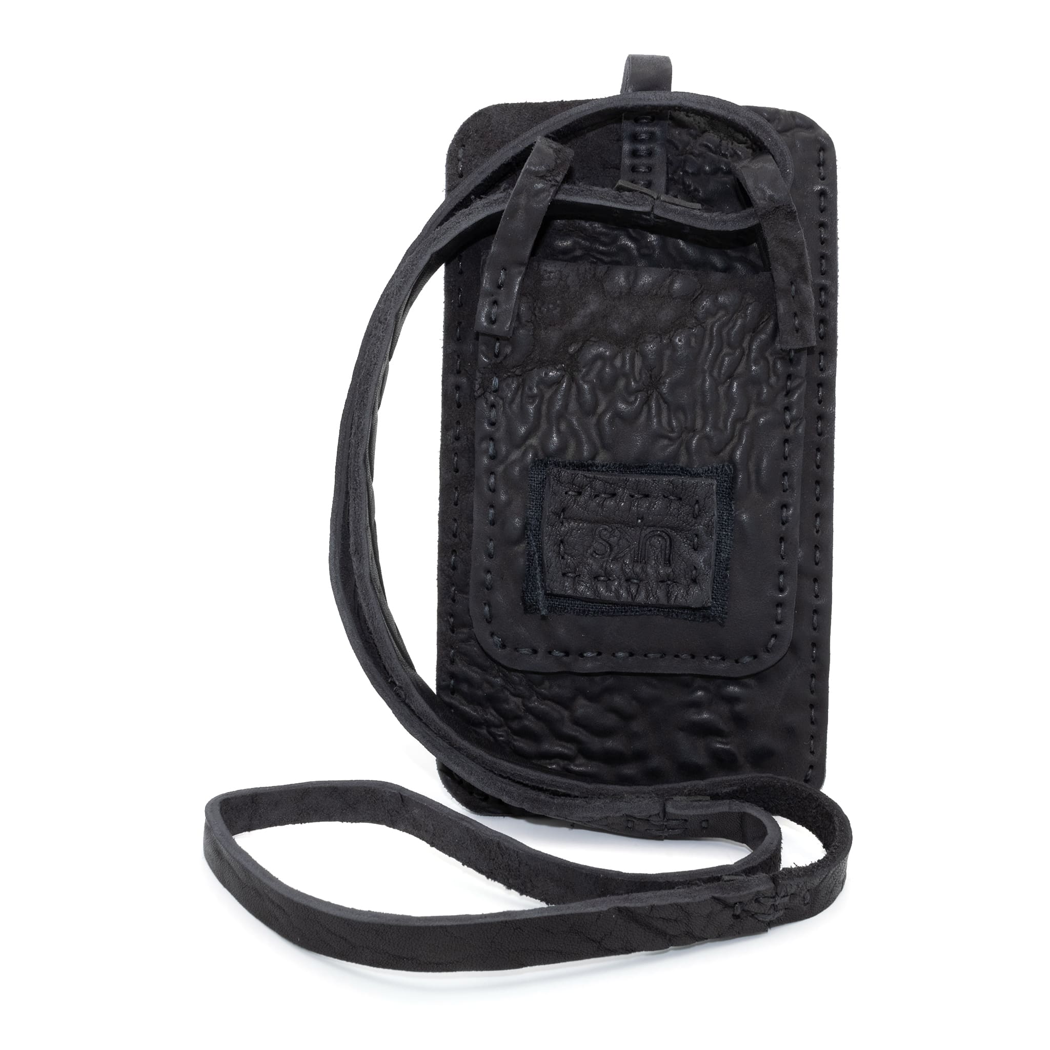 meticulously hand stitched, the washed reverse horse culatta leather phone case features a minimal silhouette, with a distressed iron dye treatment, tonal linen stitching and a card slot to the rear. the phone holder is available to buy online from avant garde designer atelierskn.com 
