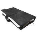 Hand stitched object dyed grey reverse horse culatta leather journal cover with a hand forged solid burnt bronze nail closure, interior pockets and multiple pages of 150gsm handmade cotton rag paper. available to buy online from artisanal uk based leather studio atelier skn.
