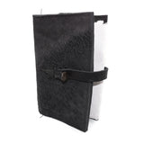 Hand stitched object dyed grey reverse horse culatta leather journal cover with a hand forged solid burnt bronze nail closure, interior pockets and multiple pages of 150gsm handmade cotton rag paper. available to buy online from artisanal uk based leather studio atelier skn.