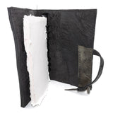 Hand stitched object dyed grey reverse horse culatta leather journal cover with a hand forged solid burnt bronze nail closure, interior pockets and multiple pages of 150gsm handmade cotton rag paper. available to buy online from artisanal uk based leather studio atelier skn.