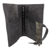 Hand stitched object dyed grey reverse horse culatta leather journal cover with a hand forged solid burnt bronze nail closure, interior pockets and multiple pages of 150gsm handmade cotton rag paper. available to buy online from artisanal uk based leather studio atelier skn.