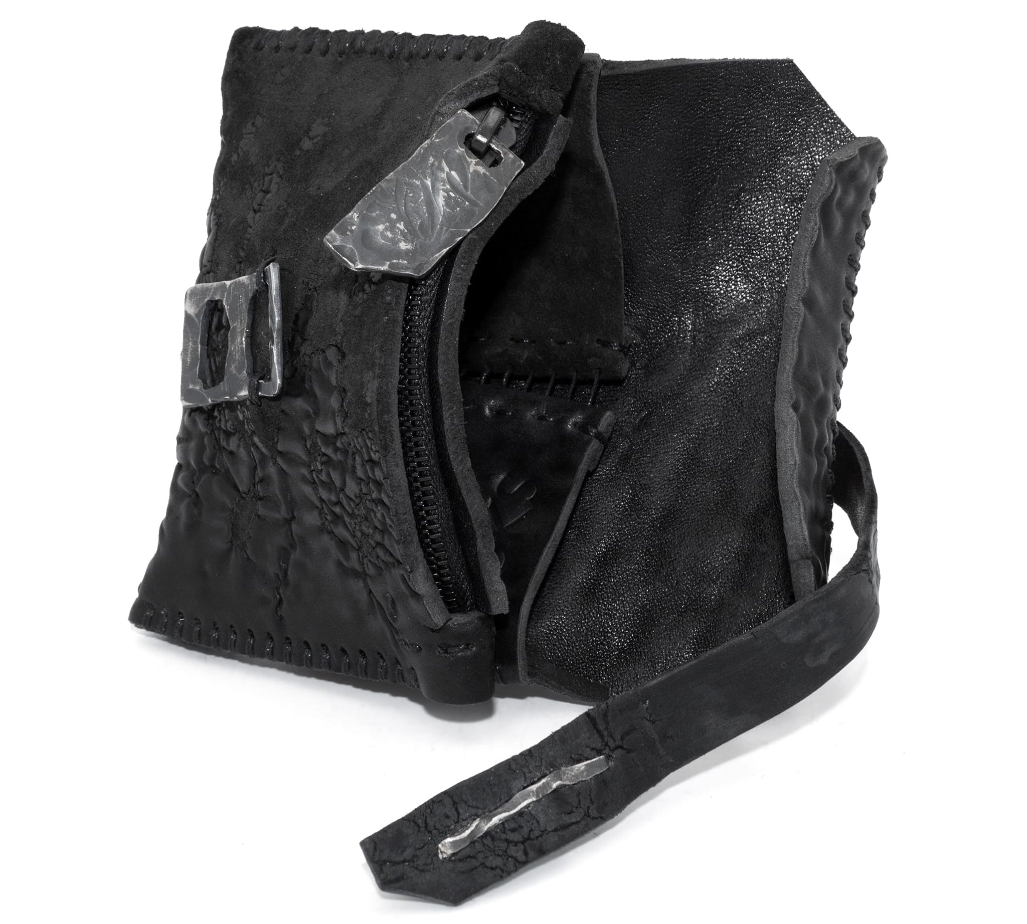 a zipper pocket cardholder crafted from a butter soft reverse culatta leather with a matte black object dyed finish in a single piece pattern construction. a riri zipper pocket is adorned with a hand forged solid .925sterling silver zipper pull, which compliments the hand forged solid silver buckle closure, available to buy online from artisanal leather studio atelierskn.com
