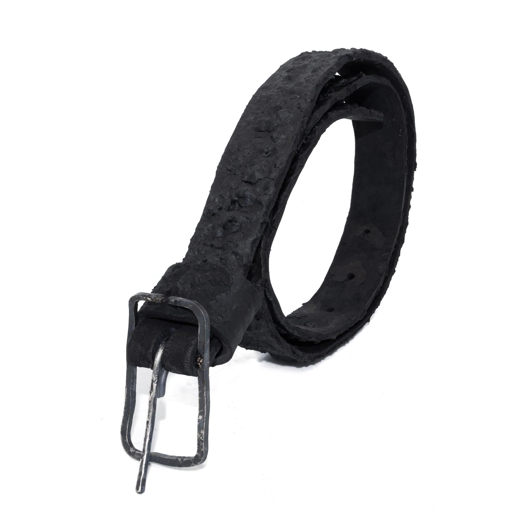 the pyroclastic belt features multiple layers of volcanic ash, sterling silver, burnt bronze layered over 28 days on top of an object dyed matte black full grain reverse horse culatta leather belt. with a hand forged oxidised .925 sterling silver buckle for men and women. expertly hand sewn by independent UK based artisanal designer atelier SKN.